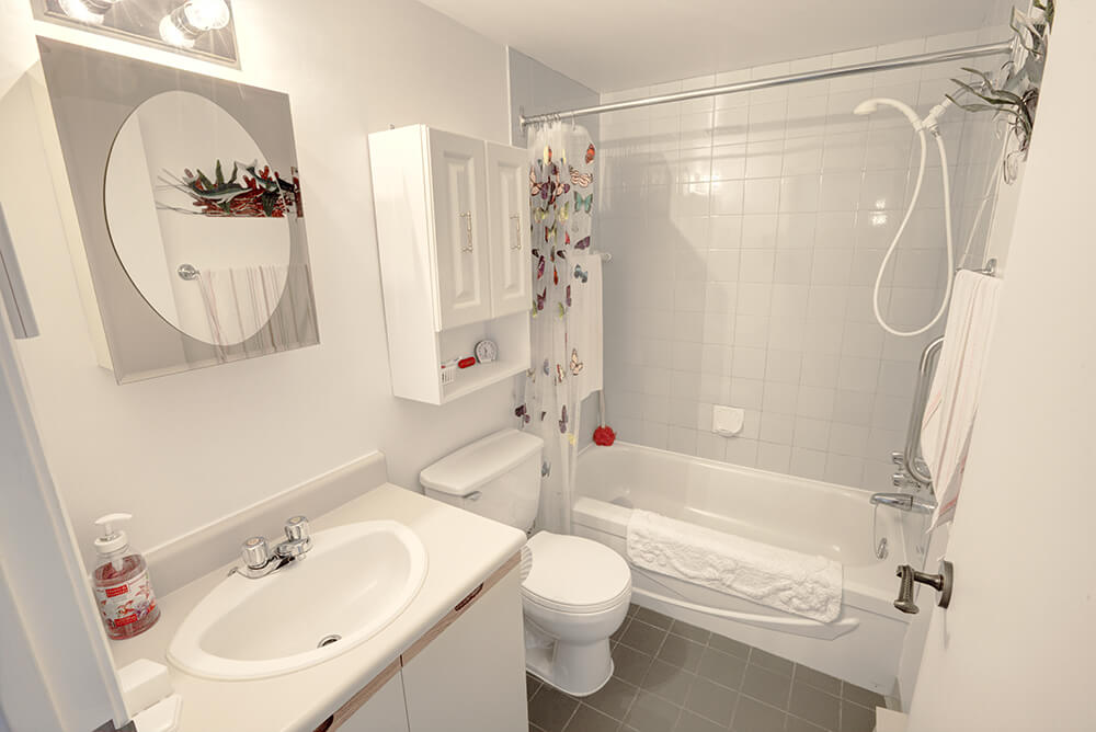 Salle de bain blanche d'un logement 4 1/2 des immeubles Pinard