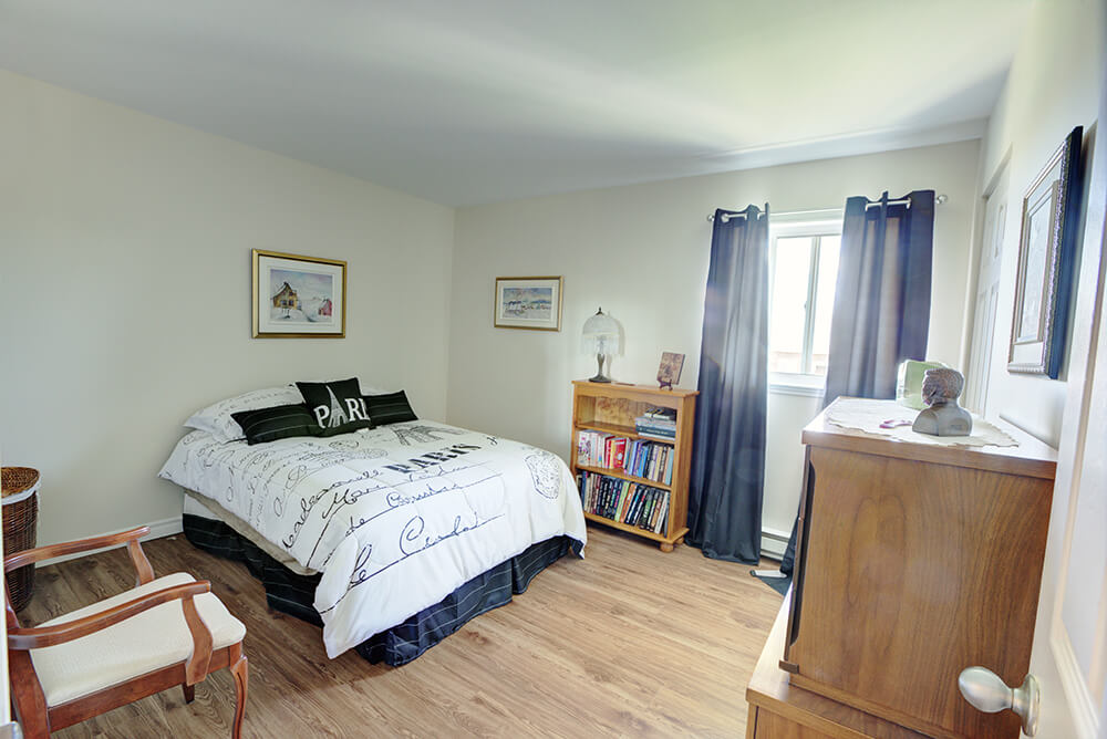 Chambre avec meubles en bois d'un logement 4 1/2 des résidences Melrose